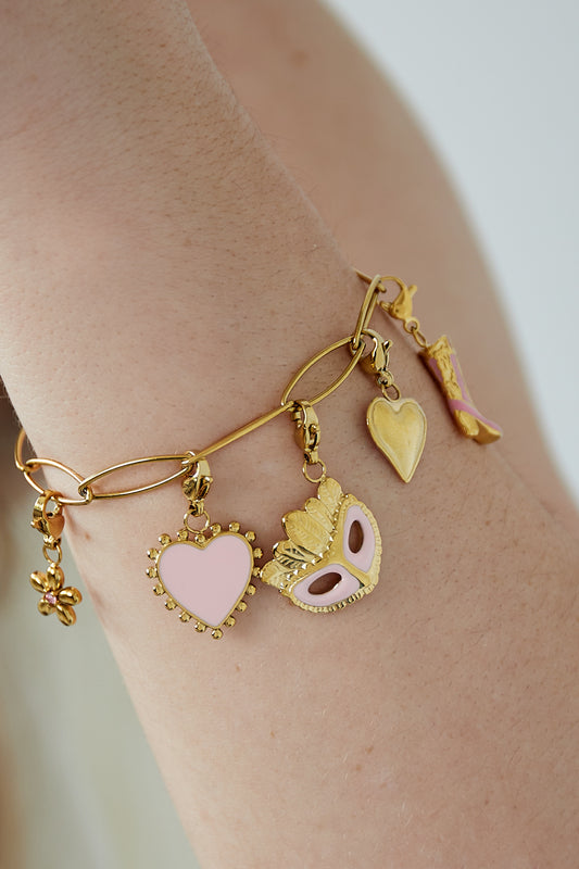 Gyllene glamorös berlockarmband med lekfulla rosa detaljer