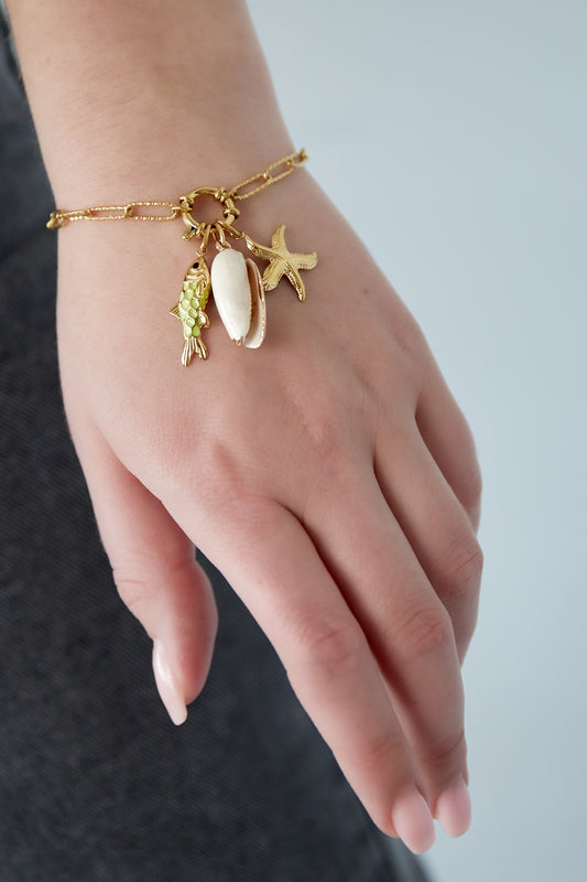 Gyllene armband med strandvibbar och havstema-berlocker