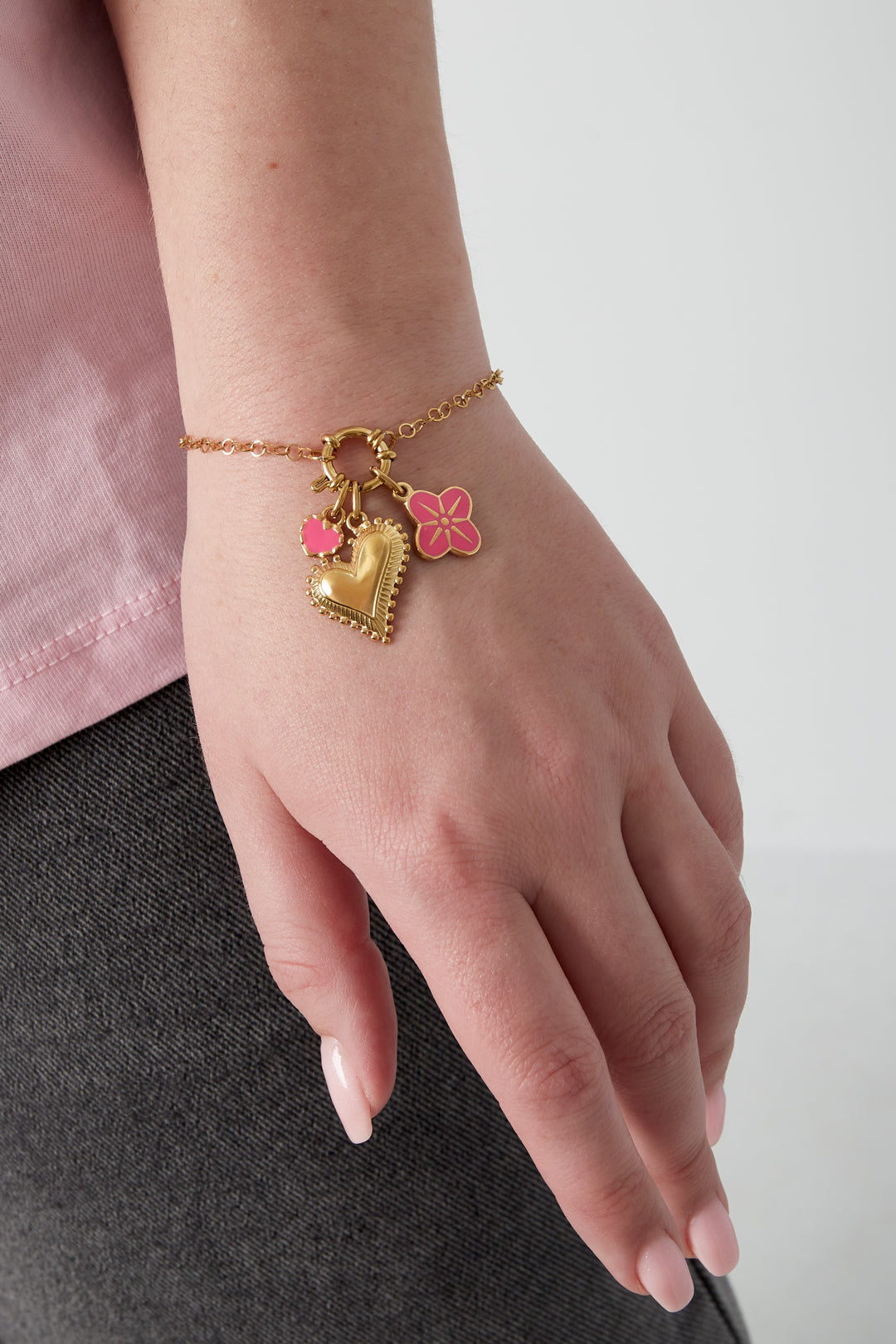 Hjärtformat armband i gyllene färg med utbytbara kärleksberömmelser